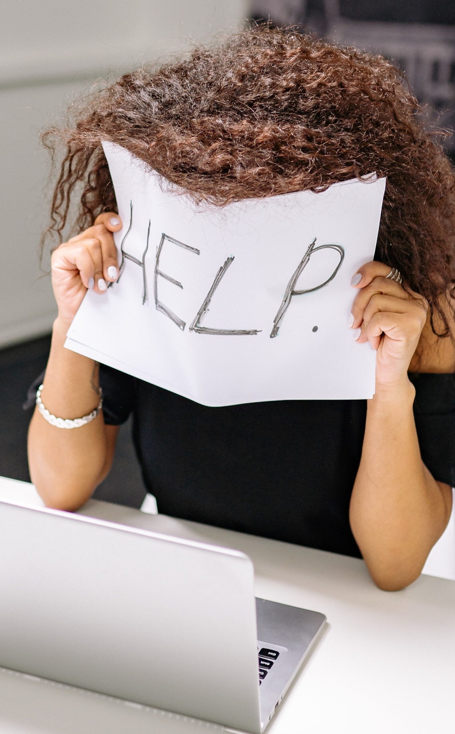 Personne demandant de l'aide en montrant un panneau "help"